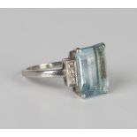 An aquamarine and diamond ring, claw set with a cut cornered rectangular step cut aquamarine between