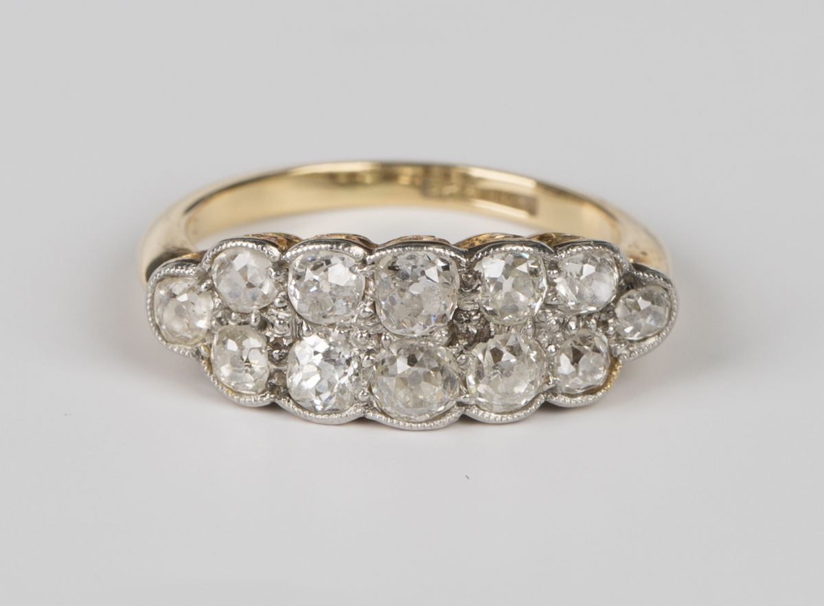 A gold, platinum and diamond ring in a two row boat shaped design, mounted with cushion cut