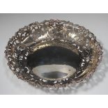 An Edwardian silver circular dish, pierced and engraved with a border of flowers, foliate scrolls