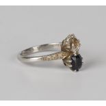 A platinum, white gold, diamond and sapphire ring, claw set with a cushion shaped diamond and a