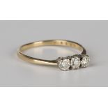 An 18ct gold and diamond three stone ring, claw set with a row of circular cut diamonds,