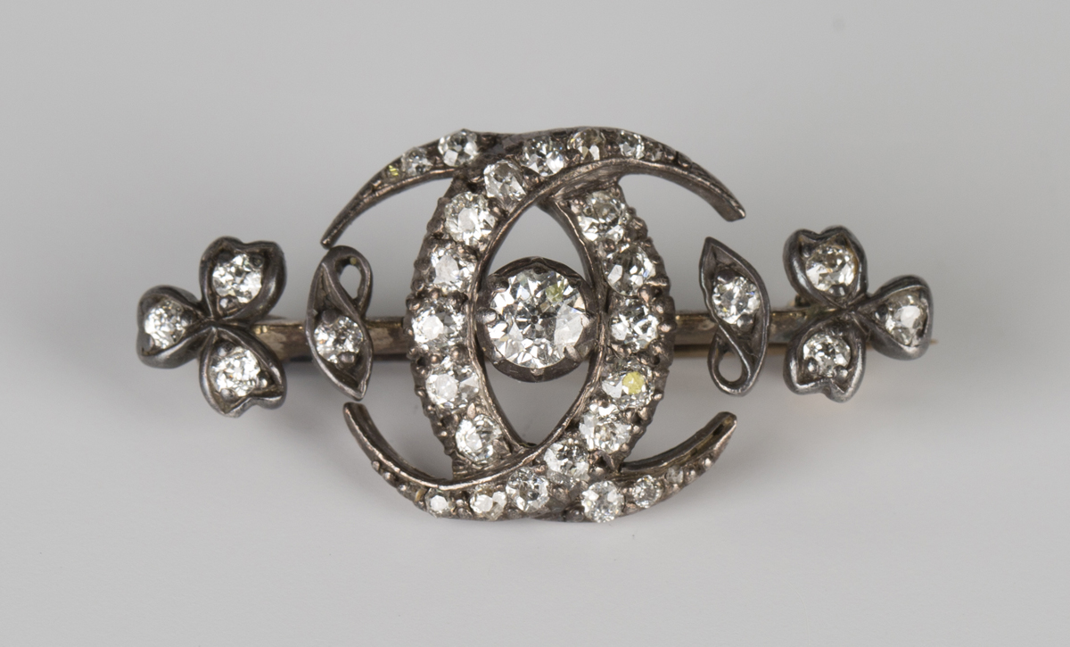 A Victorian gold backed and silver set diamond brooch, designed as two interlinked crescents and a