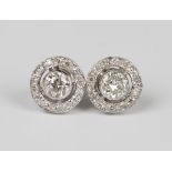 A pair of white gold and diamond earstuds, each collet set with the principal circular cut diamond