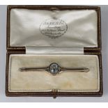 A gold and white metal fronted aquamarine single stone bar brooch, collet set with an oval cut