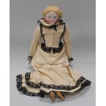 A 19th century Parian head and shoulders doll with painted moulded hair, eyes and mouth and fabric