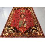 A Ghashghai pictorial carpet, South-west Persia, mid-20th century, the red field with a shaped