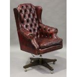 A late 20th century buttoned claret leather wingback revolving office chair, height 120cm, width