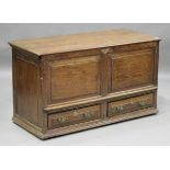 A George III provincial oak mule chest, the hinged lid above a panelled front and two drawers,