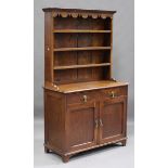 An early 20th century oak dresser, the shelf back above two drawers and cupboards, on bracket