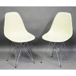 A pair of modern cream moulded plastic and chromium plated metal Eames 'DSR' style chairs, raised on