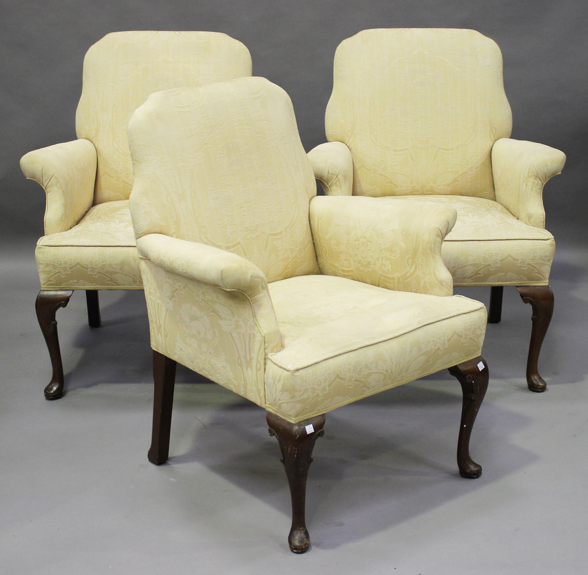 A set of three early 20th century Queen Anne style scroll armchairs, upholstered in patterned yellow