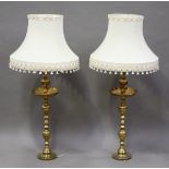 A pair of 20th century Indian brass candlesticks with engraved decoration and flared drip pans,