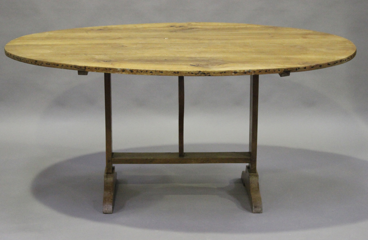 A late 19th century French fruitwood tilt-top vendange or wine tasting table, the oval top on a