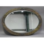 An early 20th century hammered brass oval wall mirror, 83cm x 59cm.Buyer’s Premium 29.4% (