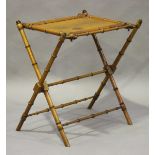 A late Victorian satin walnut folding coaching table, the panelled top on faux bamboo supports,