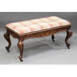 A mid-Victorian walnut box seat stool, the blind fretwork frieze raised on carved cabriole legs