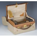 An early 20th century brown leather lady's travelling vanity case with gilt brass fittings, the