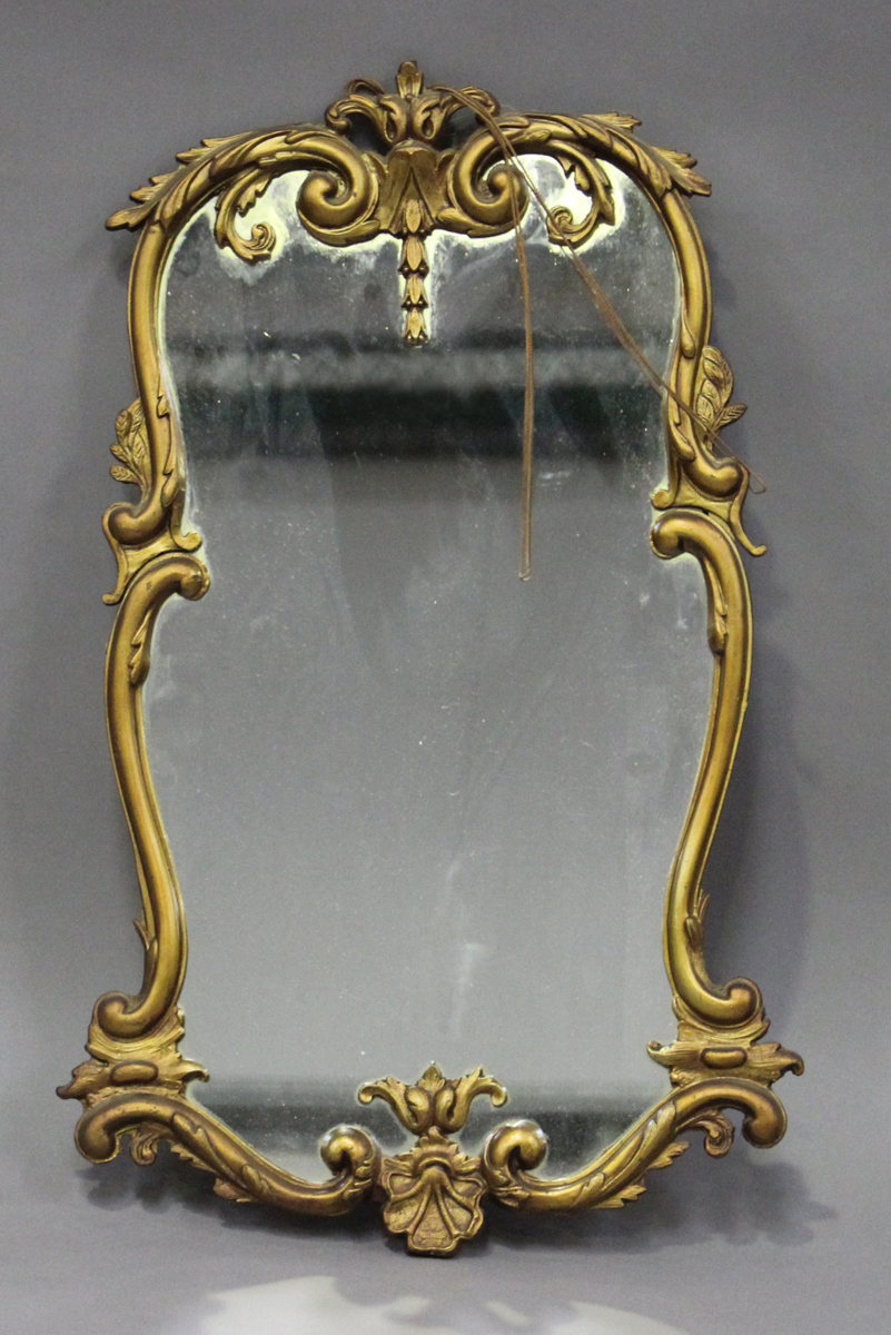 A mid-20th century cast gilt metal wall mirror with a foliate cartouche frame, 64cm x 36cm.Buyer’s