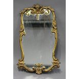 A mid-20th century cast gilt metal wall mirror with a foliate cartouche frame, 64cm x 36cm.Buyer’s