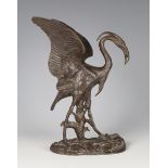 A late 19th century brown patinated cast bronze model of a stork, standing on a naturalistic base