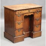 A 19th century oak kneehole desk, fitted with an arrangement of eight drawers and a cupboard, on a