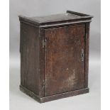 An 18th century oak spice cabinet, the door enclosing shelves, height 55.5cm, width 43cm, depth 32cm
