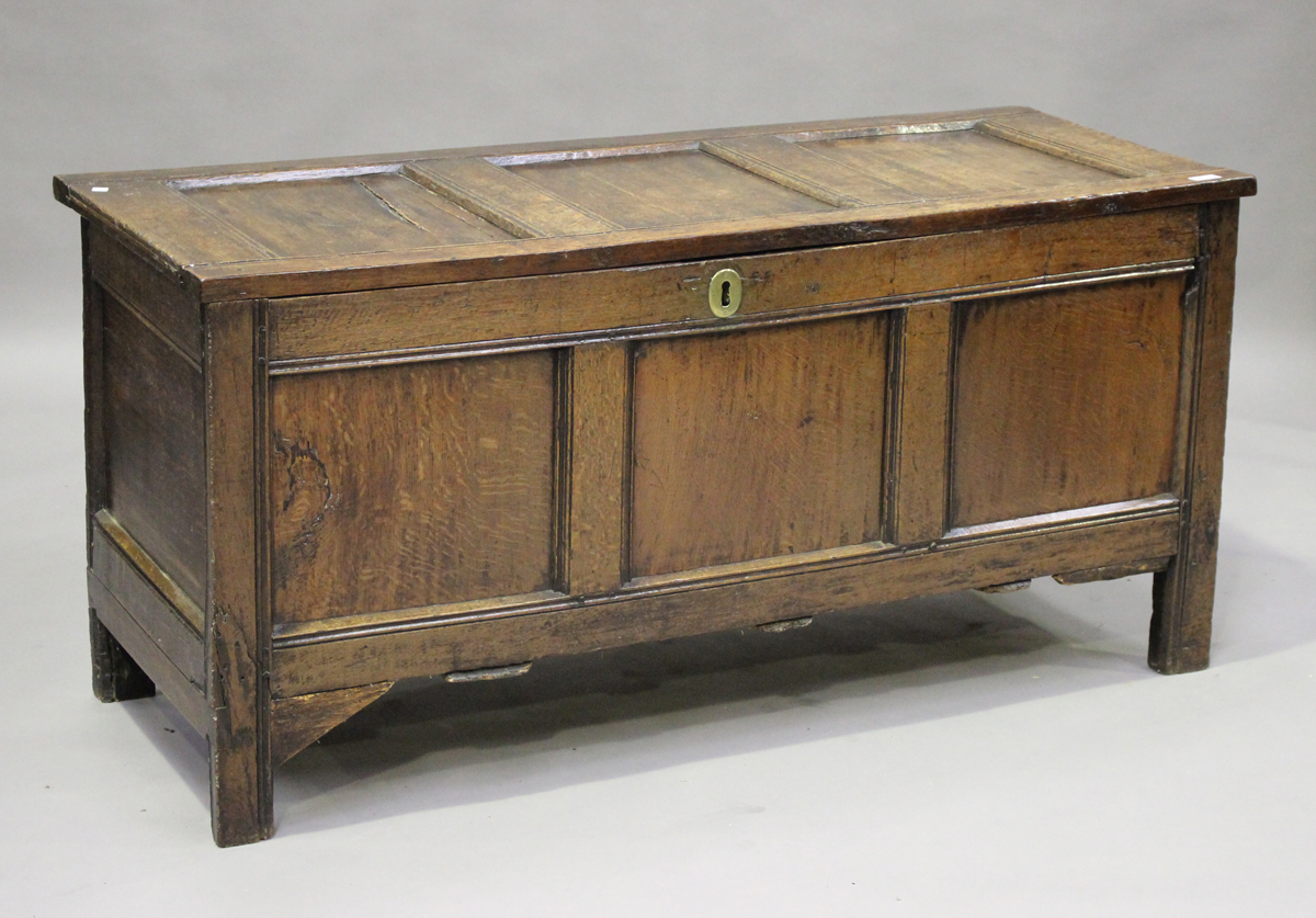 An early 18th century panelled oak coffer with channel moulded decoration, height 68cm, width 141cm,