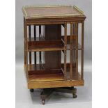 An Edwardian mahogany revolving bookcase, the moulded top fitted with a gilt brass balustrade