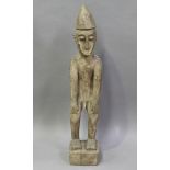 An African carved wooden standing figure with light coloured surface, height 94cm.Buyer’s Premium
