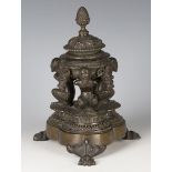 A 19th century Continental brown patinated cast bronze inkwell, the lidded body supported by three