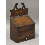 A late George III provincial mahogany wall mounted candle box, the shaped backplate inlaid with