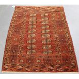 A Tekke rug, West Turkestan, early 20th century, the claret field with two columns of guls, within