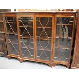 An Edwardian mahogany breakfront bookcase, the four astragal glazed doors enclosing adjustable