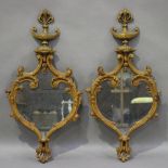 A pair of late 19th century Rococo Revival carved softwood wall mirrors, the frames with urn finials
