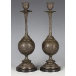 A pair of late 19th century French patinated spelter candlesticks, the spherical bodies cast with