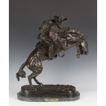 After Frederic Remington - The Bronco Buster, a mid/late 20th century brown patinated cast bronze