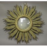 A late 20th century carved giltwood sunburst wall mirror with central convex plate, diameter 63cm.