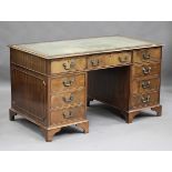 An early 20th century George III style mahogany twin pedestal desk, the top inset with leather above