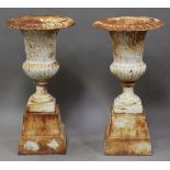 A pair of 20th century white painted cast iron garden urns, raised on integral pedestal bases,