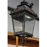 A 20th century oxidized metal hanging lantern, the domed top above tapering glazed sides and
