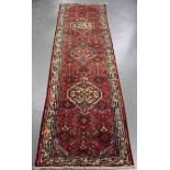 A Hamadan runner, North-west Persia, mid-20th century, the red field with a column of medallions,
