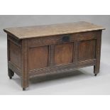 An early 18th century oak coffer, the hinged lid above a carved panel front, on stile legs, height