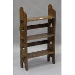 An Edwardian Arts and Crafts oak bookshelf, the sides with peg joints and pierced trefoils, height