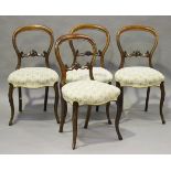 A set of four mid-Victorian walnut spoon back dining chairs with carved and pierced centre rails,