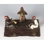 A 20th century Bergman style cold painted cast bronze figure group of three young Arabian boy