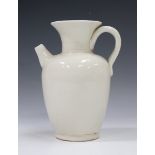 A Chinese Ding ware jug, the ovoid body with flared neck, loop handle and short spout, covered in