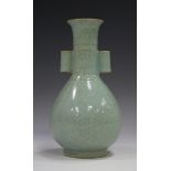 A Chinese celadon glazed bottle vase, the pear form body beneath a narrow neck and tubular