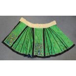 A Chinese green silk embroidered apron skirt, early 20th century, worked in coloured threads with