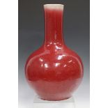 A Chinese sang-de-boeuf glazed porcelain bottle vase, Qing dynasty, the globular body with