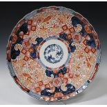 A Japanese Imari porcelain charger, Meiji period, of fluted circular form, the centre painted in